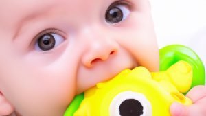 Image of a baby chewing on a baby teething toy