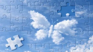 Clouds forming a jigsaw puzzle in the sky, with one piece missing and a butterfly shape emerging.