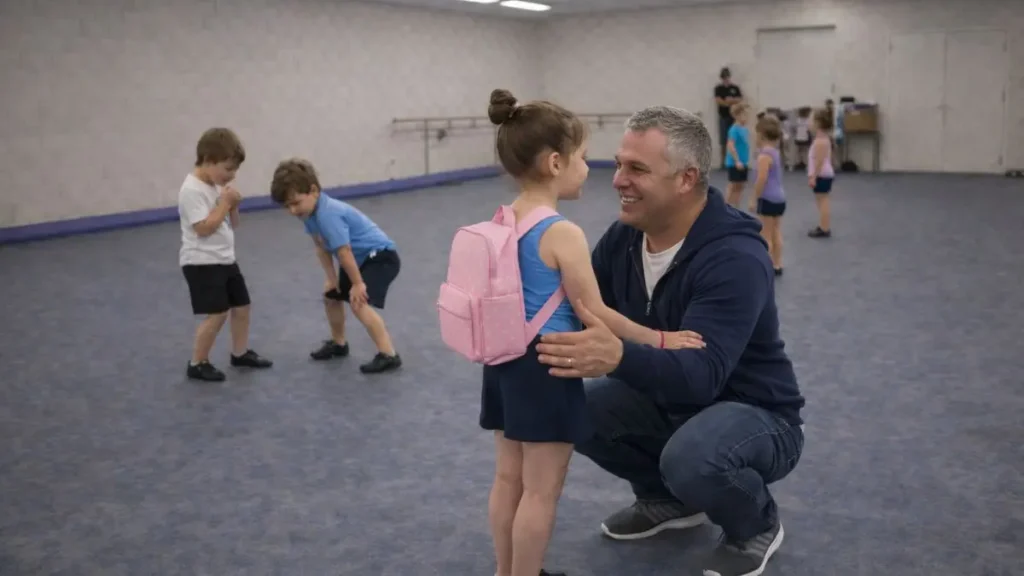 Father kneeling to greet his daughter after dance class